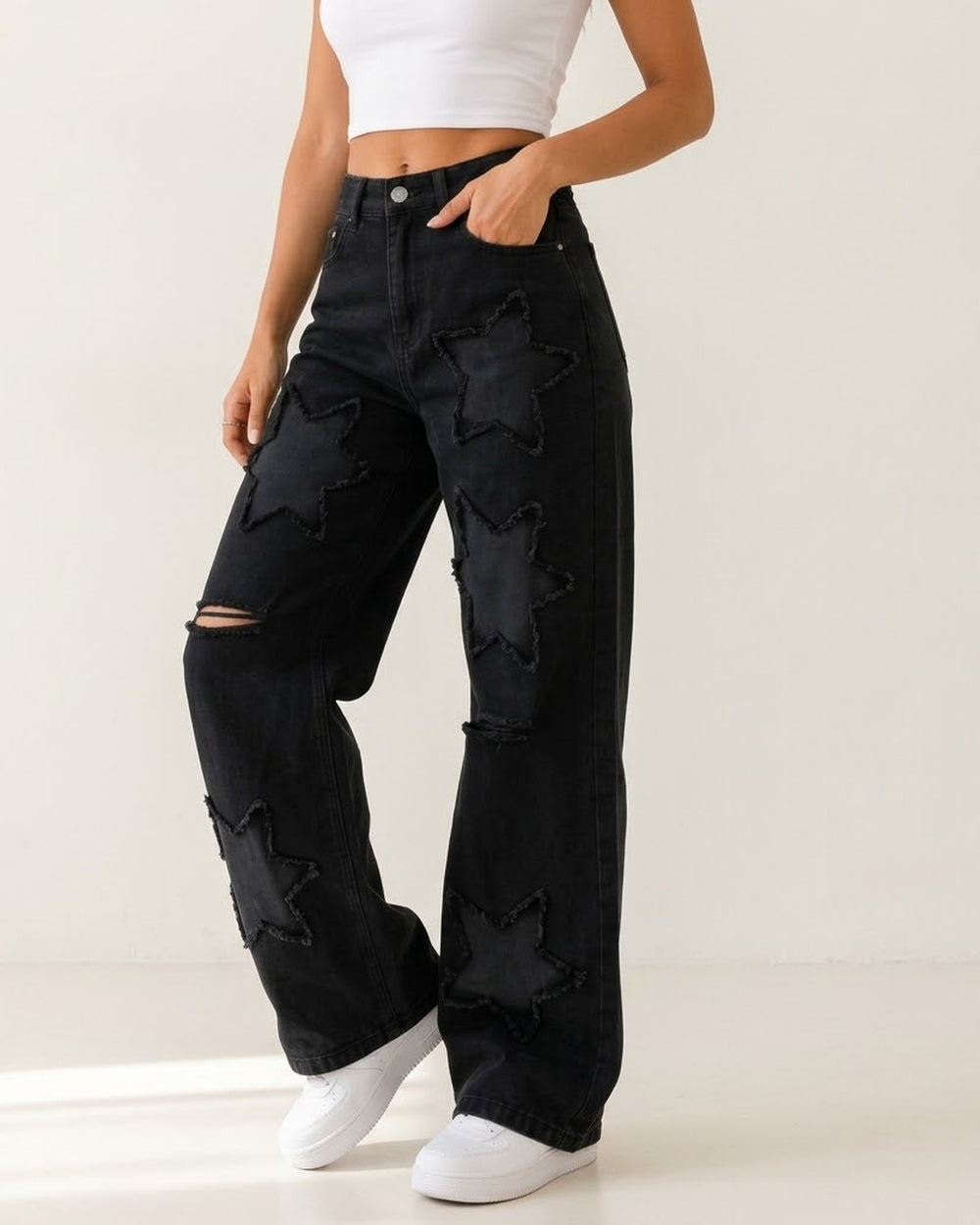 Women's black star patch wide-leg jeans on model
