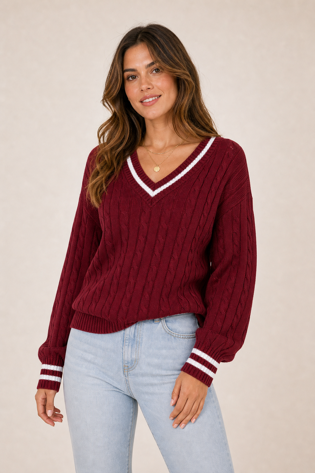 Burgundy V-neck cable sweater with white trim on model